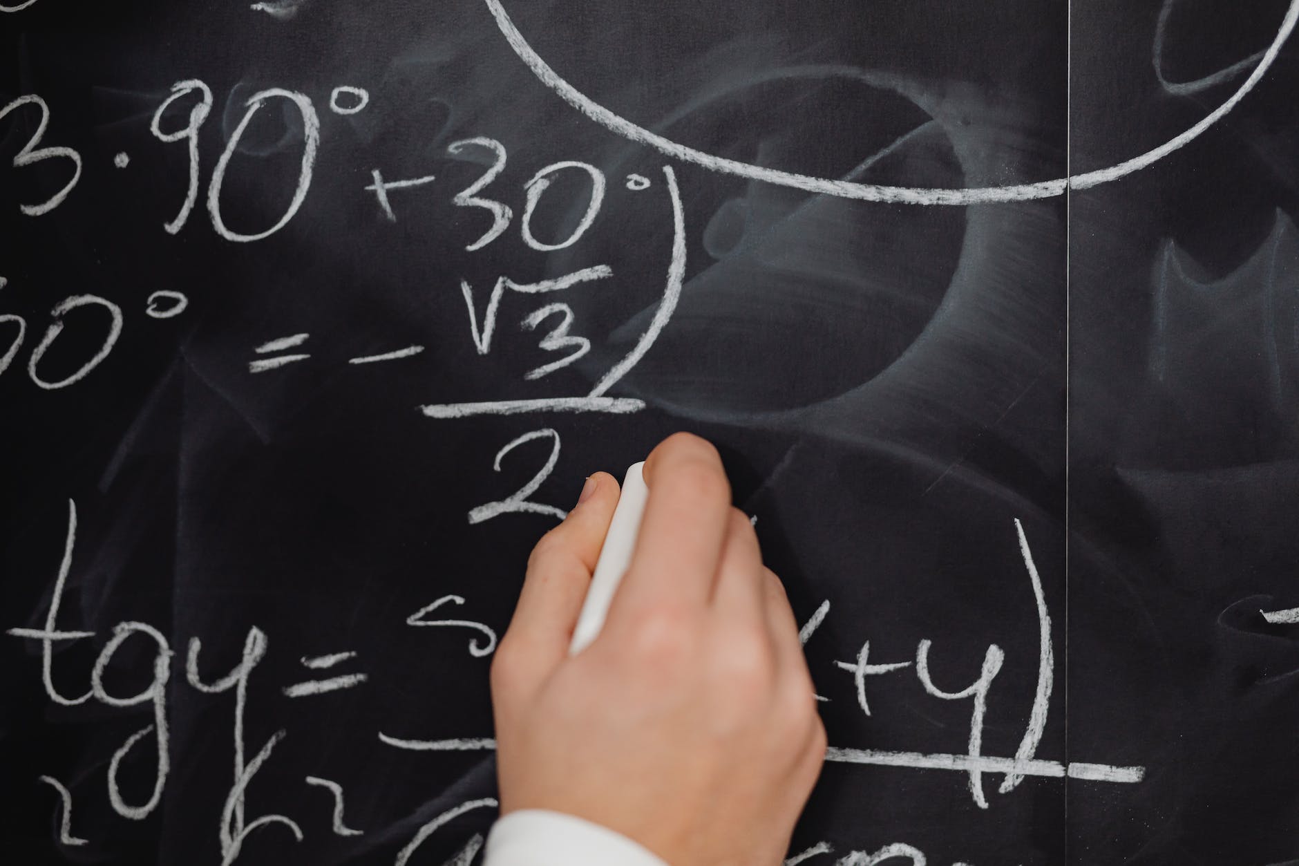 hand writing mathematical formulas on a blackboard